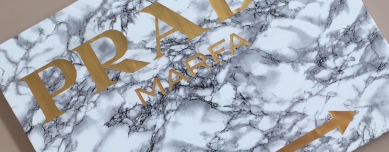 Poster « Prada marfa » avec lettres dorées sur fond marbre